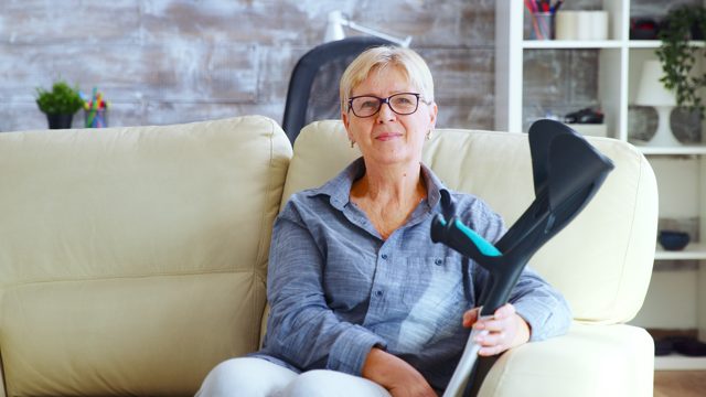 Portrait of senior woman in nursing home sitting on the couch looking being lost