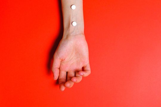 Photo of Person's Arm on Red Background