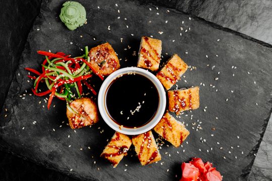 Sushi unagi rolls with soy sauce and vegetables.