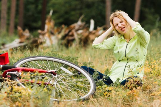 Woman sitting on ground with a headache