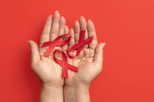 Person holding an world aids day ribbon symbol